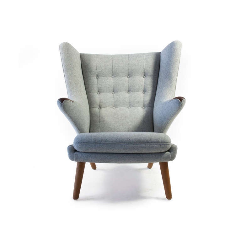 The Hans J. Wegner 'Papa Bear' chair. Designed 1951 and manufactured by AP Stolen, Denmark as model AP19.

Arms of teak and legs of patinated oak. 

New grey fabric upholstery, executed as original. 

We do always have several Papa Bears and