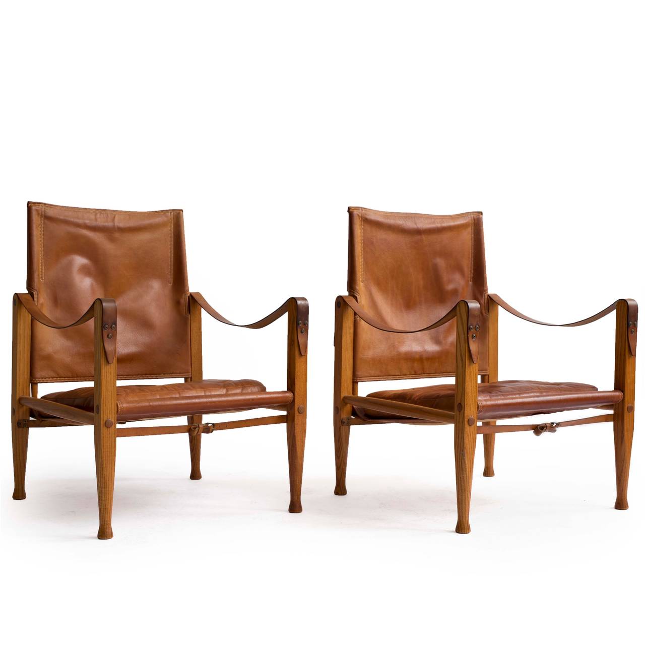 A pair of Kaare Klint 'Safari chairs' with ash frame, upholstered with original patinated natural leather. 

Designed by Kaare Klint 1933, manufactured by Rud. Rasmussen, Copenhagen, Denmark. 

Very well preserved original condition.