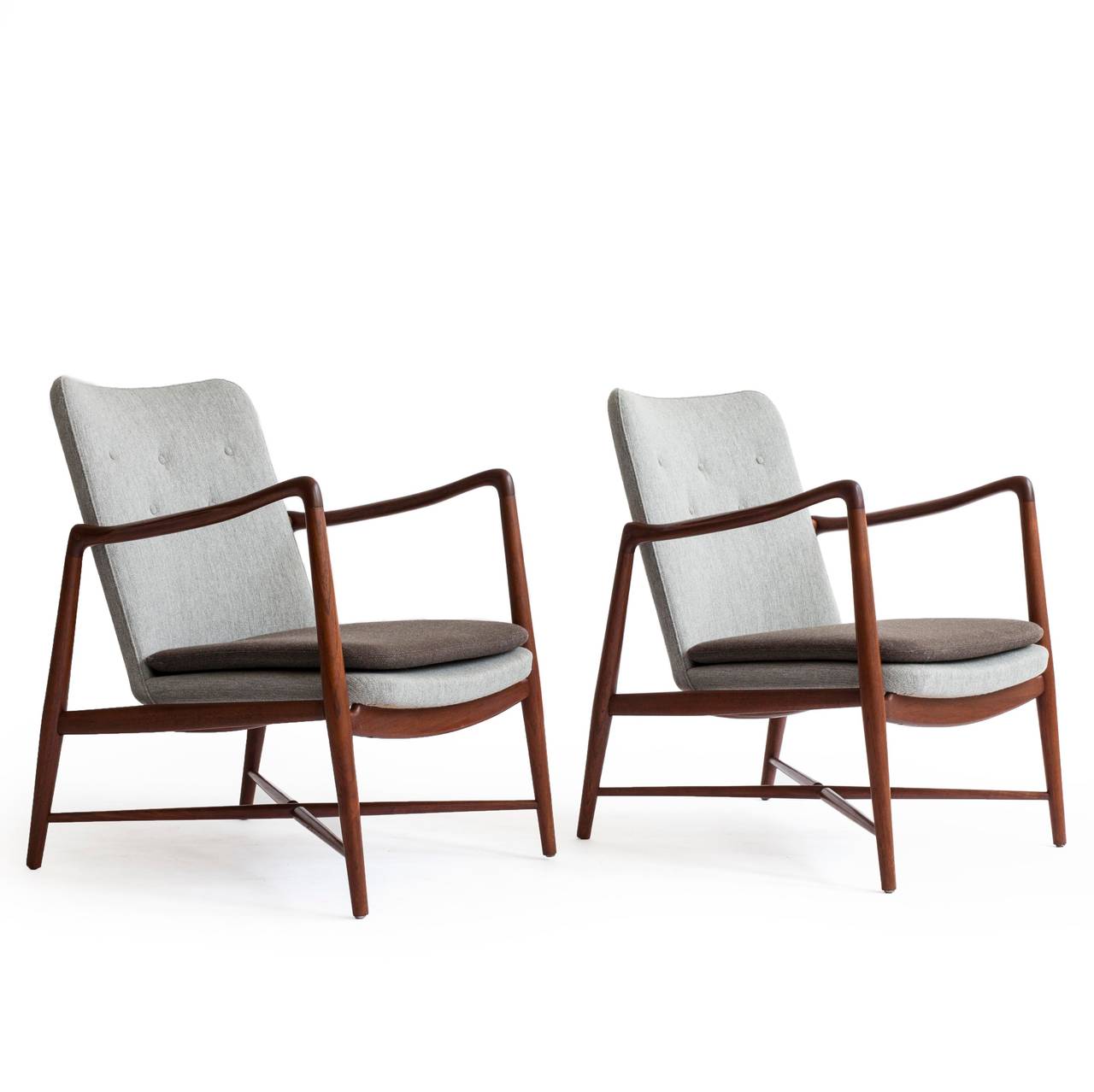 A pair of elegant Finn Juhl teak easy chairs with cross bars under seat. 

Frame of teak and new two-tone wool upholstery. 

Designed by Finn Juhl 1946 for Bovirke, Denmark, model BO59.