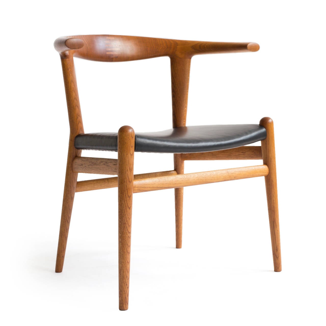 A beautiful Hans J. Wegner 'Bull Chair' with solid oak frame and black leather seat.

Designed by Hans J. Wegner 1961, made and marked by cabinetmaker Johannes Hansen, Model JH 518.