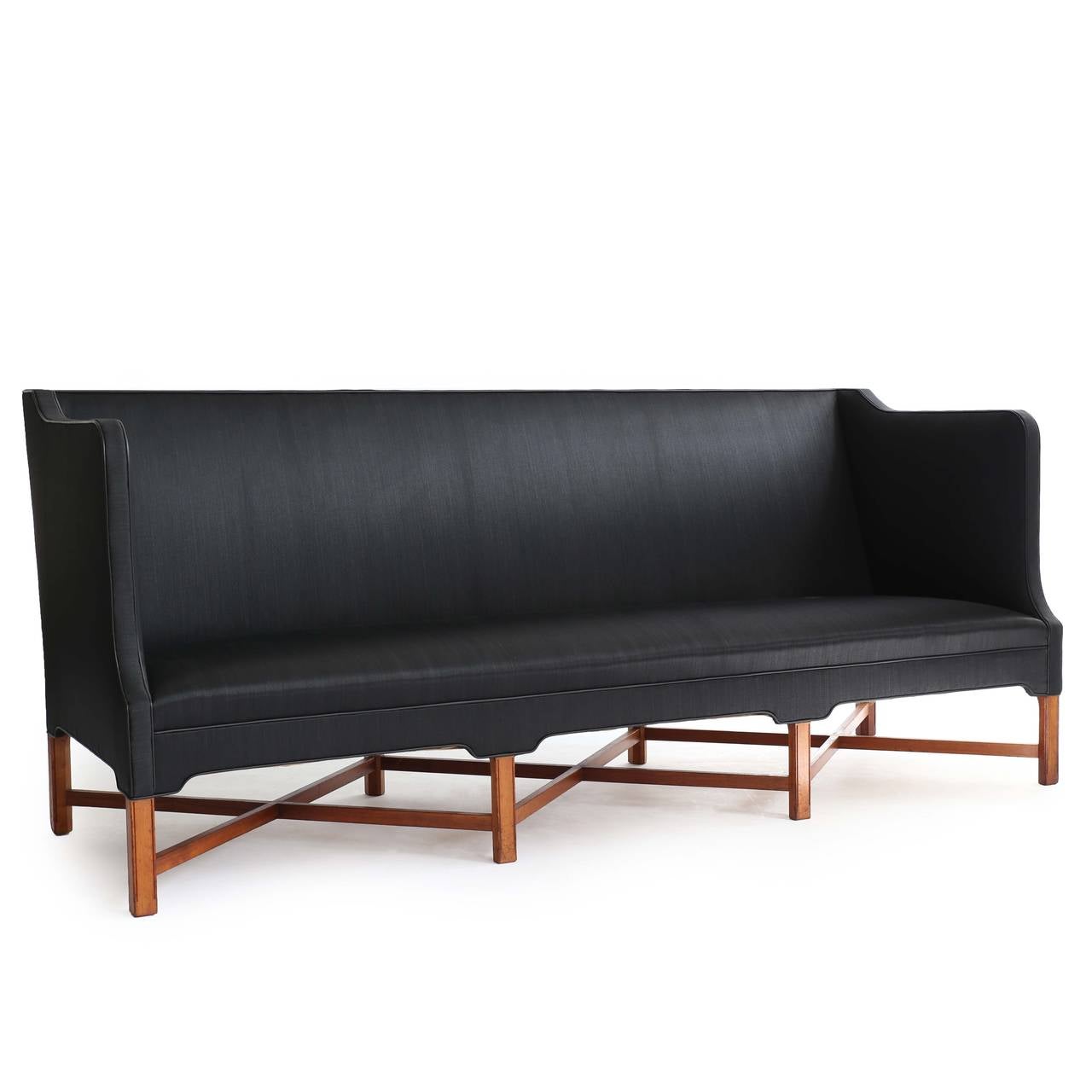 A freestanding three seater Kaare klint sofa with eight-legged profiled mahogany frame upholstered with black horsehair. 

Designed by Kaare Klint 1930 and made by cabinetmaker Rud. Rasmussen, Copenhagen, Denmark, model 4118. Underside with
