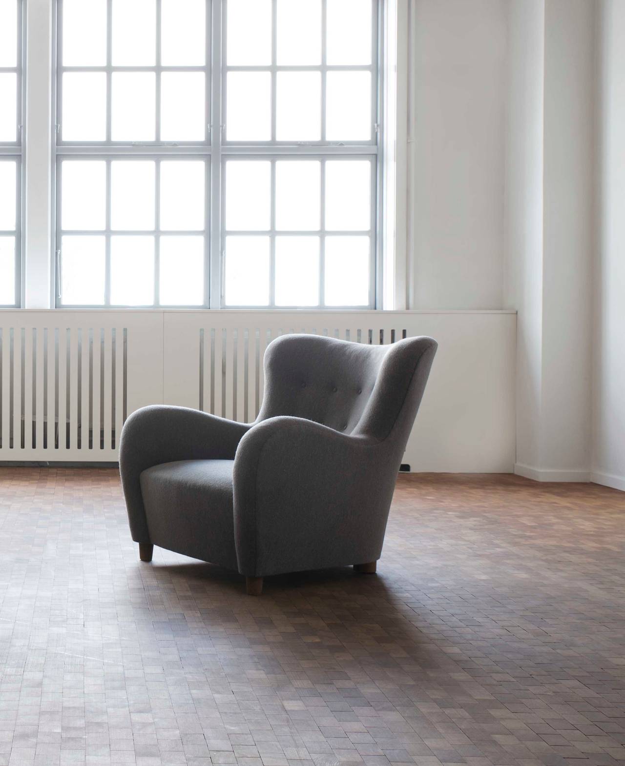 Very rare Flemming Lassen 'The Hussar' easy chair. 

Legs of stained beech, upholstered with grey brownish fabric, fitted with buttons. 

Designed for the Copenhagen Cabinetmakers' Guild Exhibition, 1935, executed by cabinetmaker A. J. Iversen.