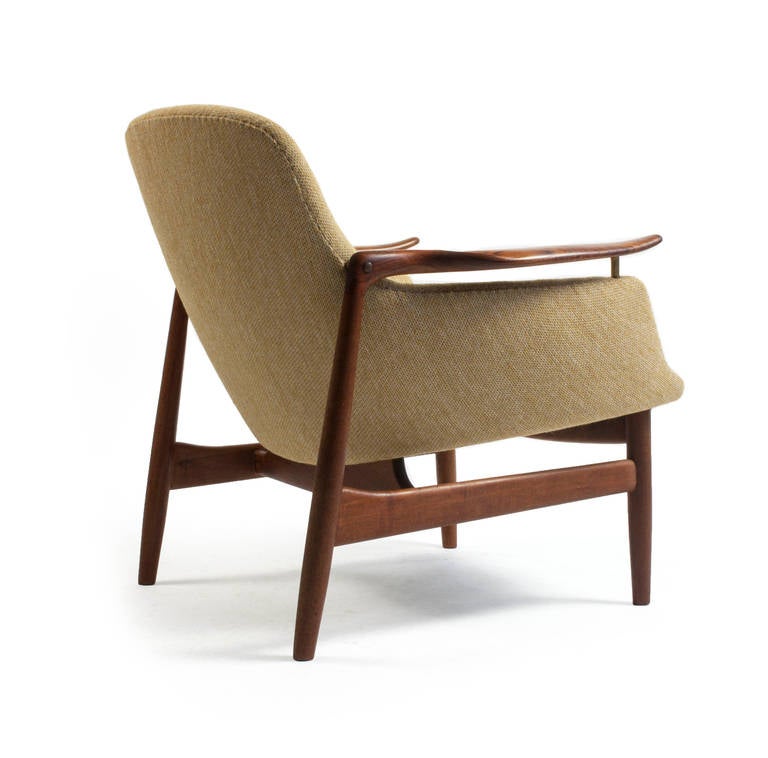 A sculptural Finn Juhl NV53 easy chair with frame of solid teak and yellow brown fabric.

Designed by Finn Juhl, 1953 manufactured and marked by cabinetmaker Niels Vodder. 

Very fine condition.
