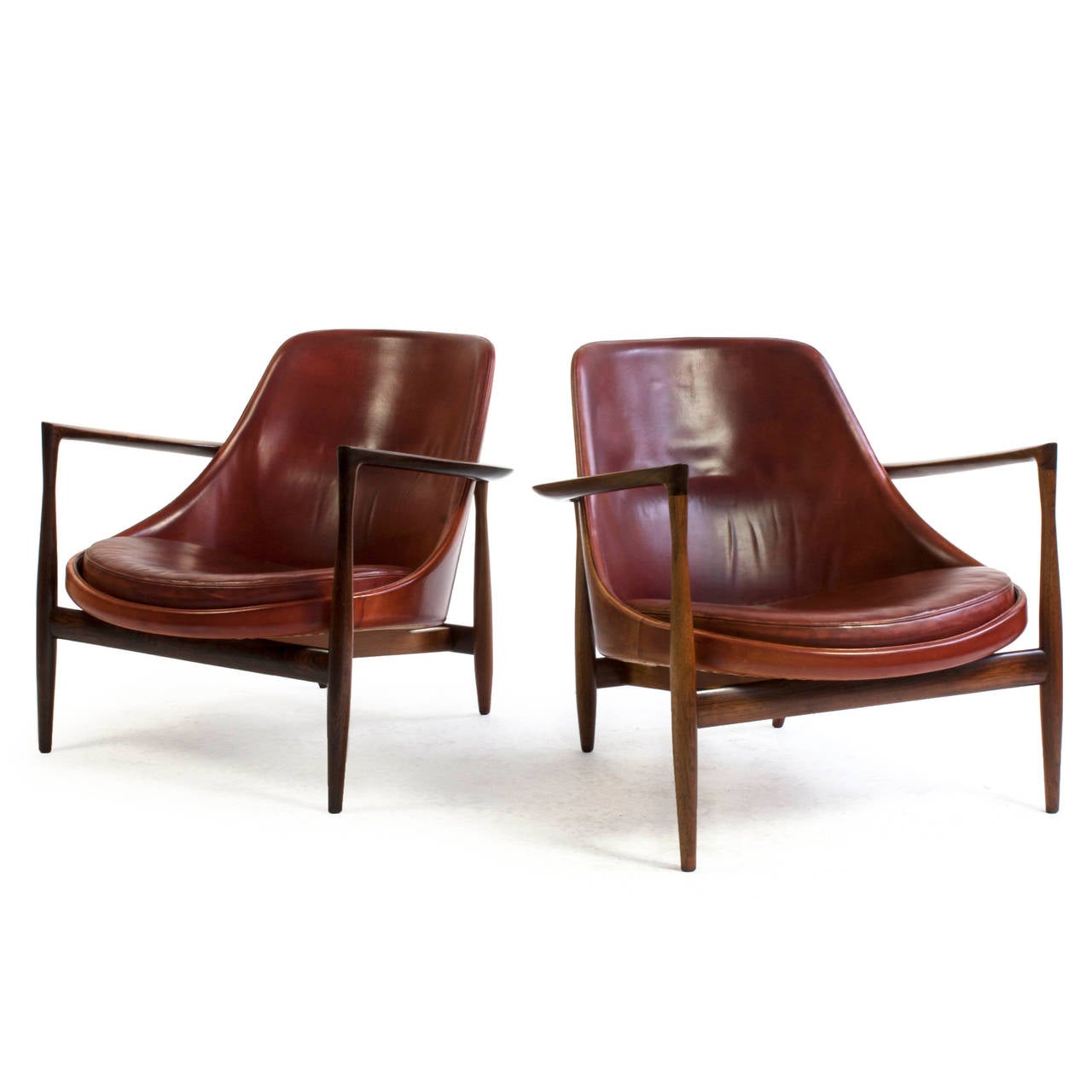 A pair of Ib Kofod-Larsen Elizabeth lounge chairs.

Exposed frame of Brazilian Rosewood and upholstered with red dyed natural leather with a beautiful red-brownish patina. 

Designed by Ib Kofod-Larsen, 1956, executed by the cabinet makers