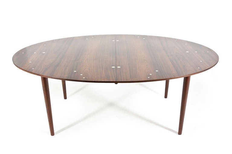 The rare Finn Juhl Judas table in Rosewood with silver inlays manufactured by Master cabinetmaker Niels Vodder. Two extension leaves. The table is in a rarely seen immaculate condition.

H. 72 cm. W. 120 cm. L. 180 cm. L. incl. leaves 290 cm
