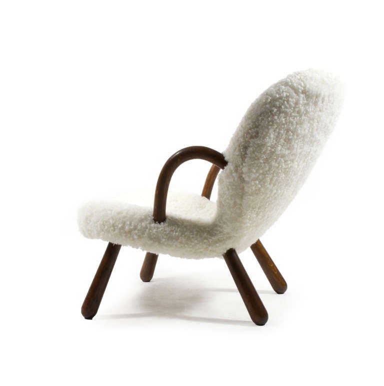 Phillip Arctander clam chair with legs of original patinated beech wood upholstered with white sheep skin. 

The chair is designed by Phillip Arktander, Denmark 1944 and manufactured by Nordisk Stål -& Møbel Central.