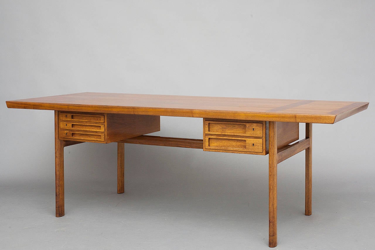 Desk by Peter Hvidt and Orla Mølgaard-Nielsen for cabinetmaker Ludvig Pontoppidan.
Designed in 1959.
Walnut.
Equipped with two turnable drawer sections, including three and two drawers. By turning each section the desk can also be used as a