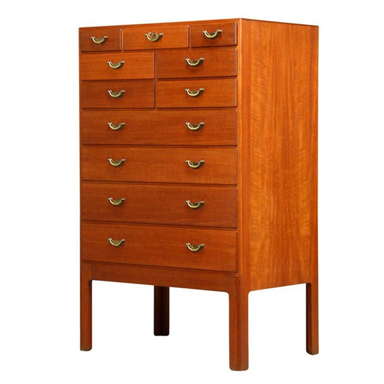 An unique teak chest of drawers, front with eleven drawers, seven of which with central locking system, brass handles.

Designed in 1947, produced by master cabinetmaker Erhard Rasmussen. 
The original receipt from master cabinetmaker Erhard
