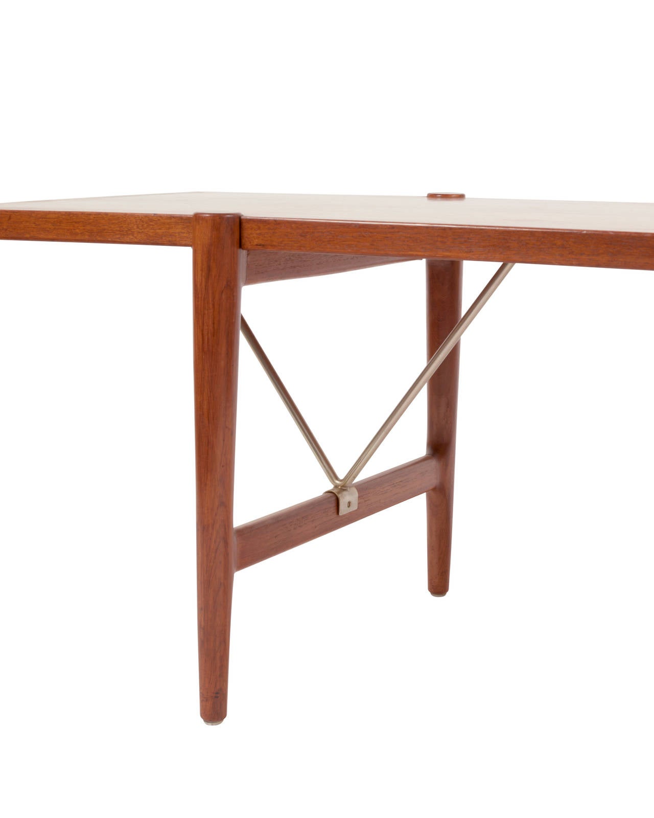 A solid teak coffee table with brass stretchers