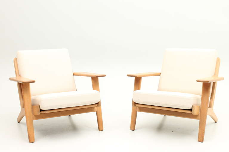 Pair of GE290 loungers in oak with new fabric cushions. Designed in the 1950s by Hans Jørgen Wegner and produced by Getama, Denmark.