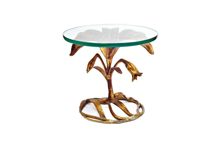 An Arthur Court sculptural side table featuring a gilt aluminum lily flower base. Original glass top with no chips.