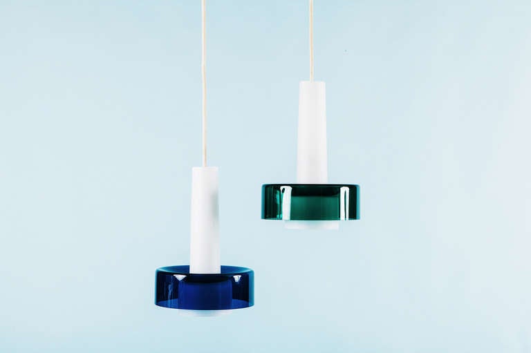 This pair of pendants, produced by Iittala, Kalvola, and Idman Oy, Helsinki have white opaque blown glass diffusers with brilliant blue and green glass shades. No chips or cracks.