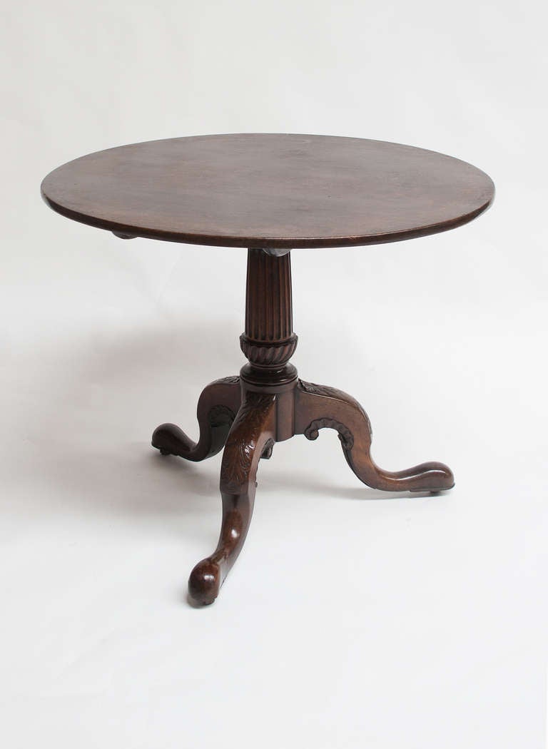 An extremely good quality, well proportioned and confidently stylised table, the well figured circular top of good original colour, retained by a banjo-catch, tilting on a bold turned and fluted gun-barrel column raised on a particularly curvy