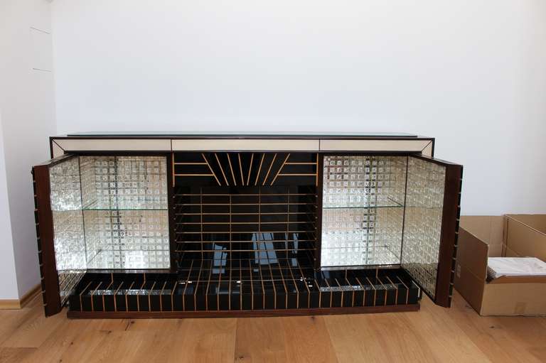 Extremely rare Borsani Bar. Italy 1970s.
Imitates a fireplace. With cut mirrors inside, black glass in combination with wood inlays. Two original keys, very good original overall condition,
comes from the Gianni Versace legacy Collection. One of a