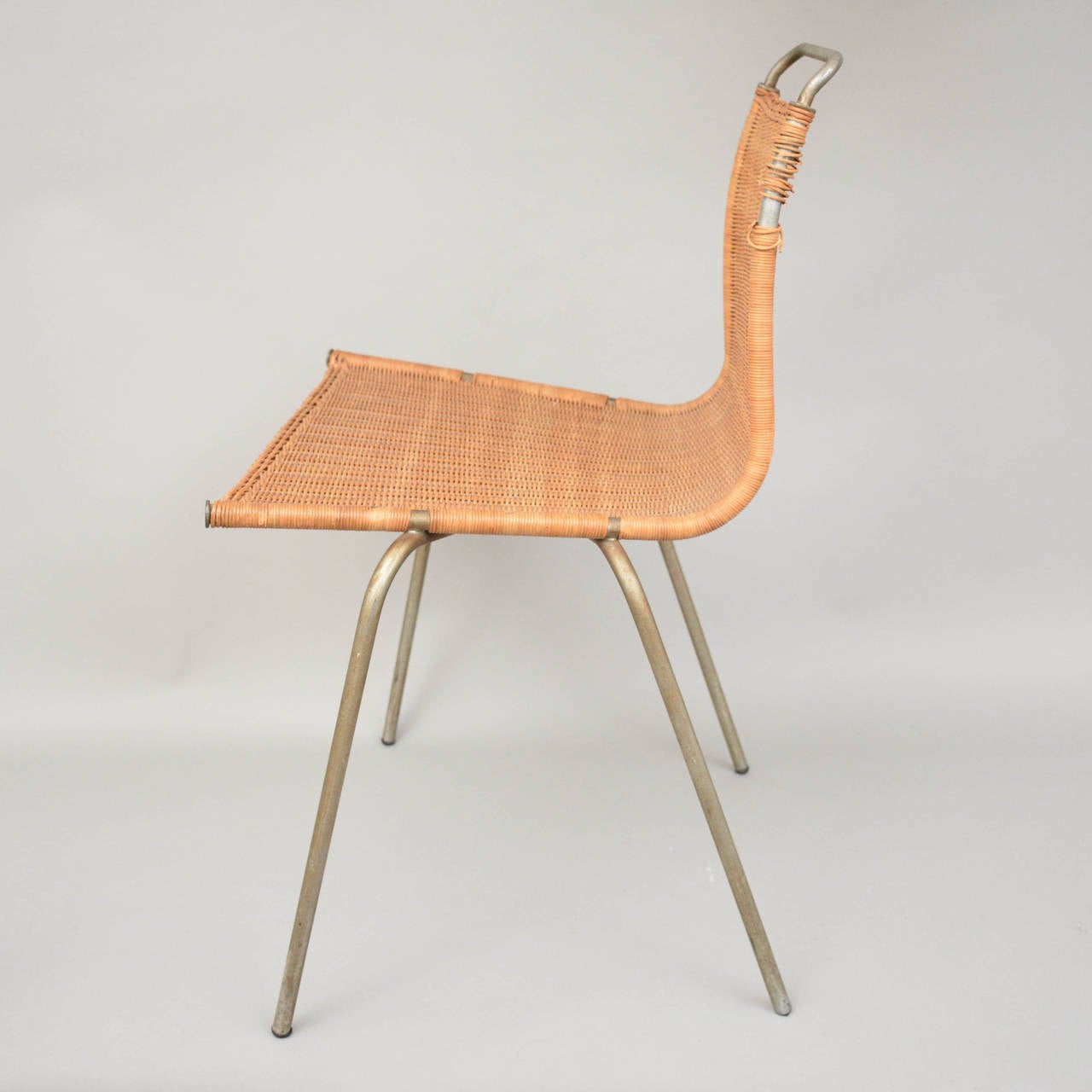 A rare original PK1 chair by Poul Christensen for E Kold Christensen, Denmark. Matt chrome-plated steel frame, woven cane seat and back. Designed in 1956.