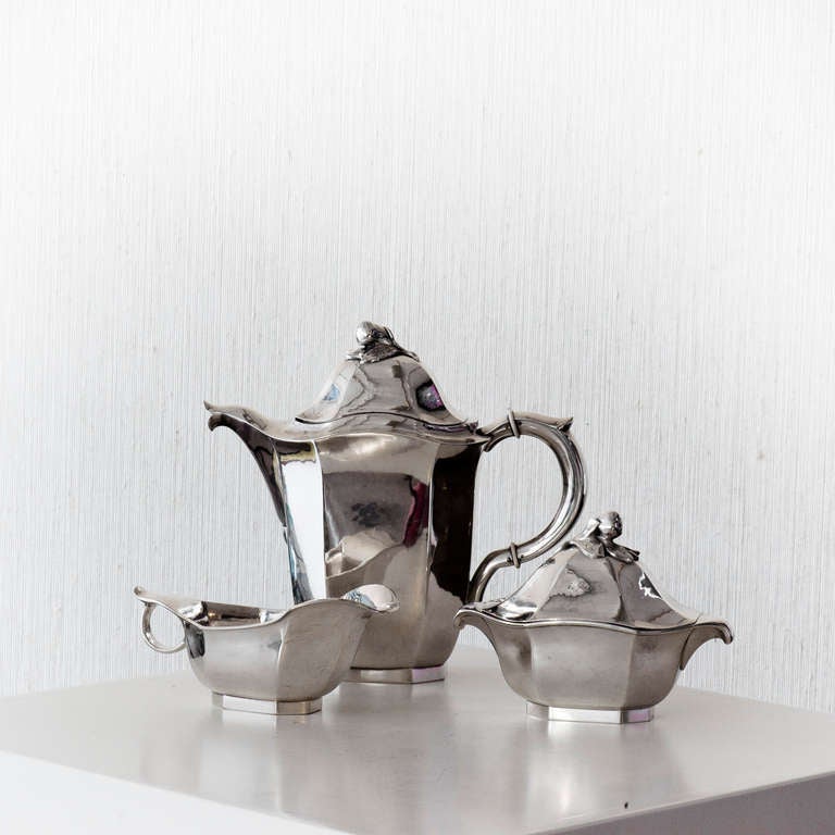 A three pieces coffee set in silver by Jacob Ängman for Guldsmeds Aktiebolaget. This model was exhibit at Metropolitan museum in 1927. Sign G.A.B Silver mark Stockholm M8=1938 N J.Ängman. The coffee h 19 cm, sugar box h 10,5 cm and the cream jug 6,5