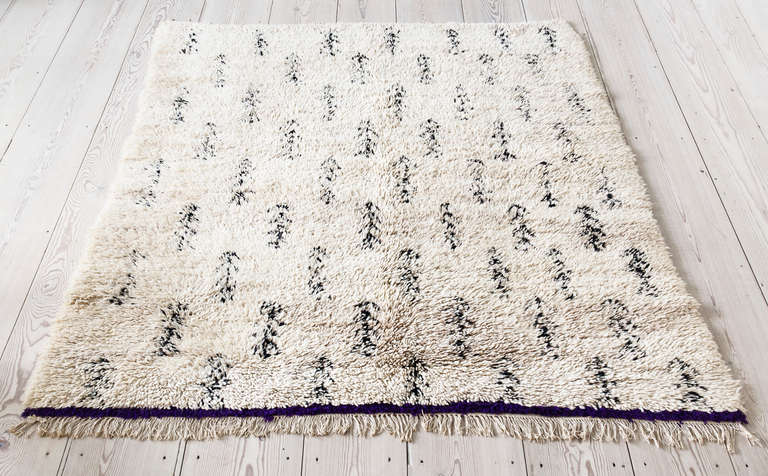 Beni Ouarain rug. White background, black pattern and dark purple border.