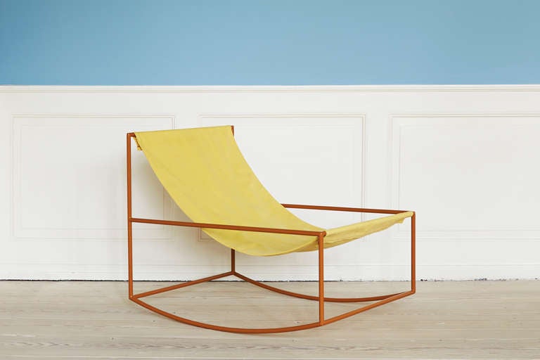 Rocking chair in lacquered steel and slung textile.