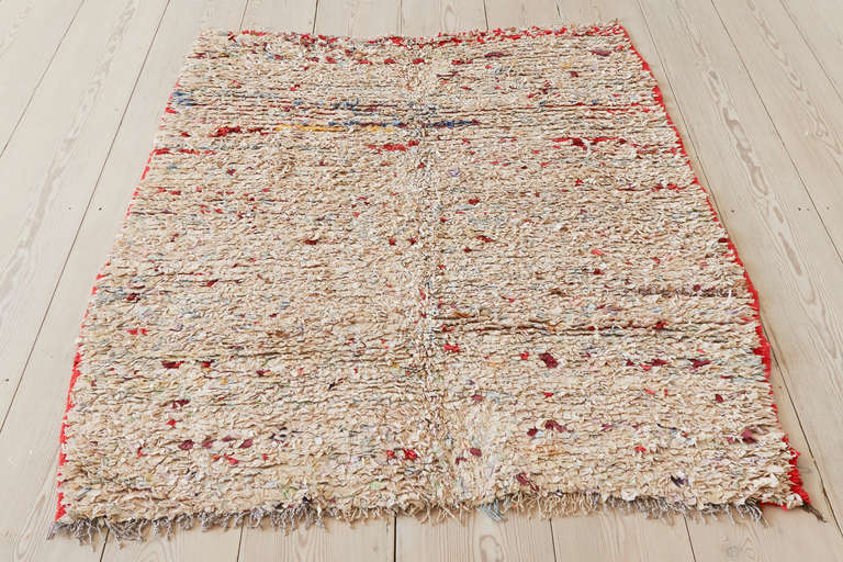 Beautiful vintage Moroccan Boucherouite rag rug. Ivory background with streaks in red and blue tones.