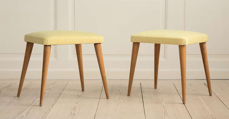 Pair of elegant 1950s stools reupholstered in white and yellow stripes on wooden legs.