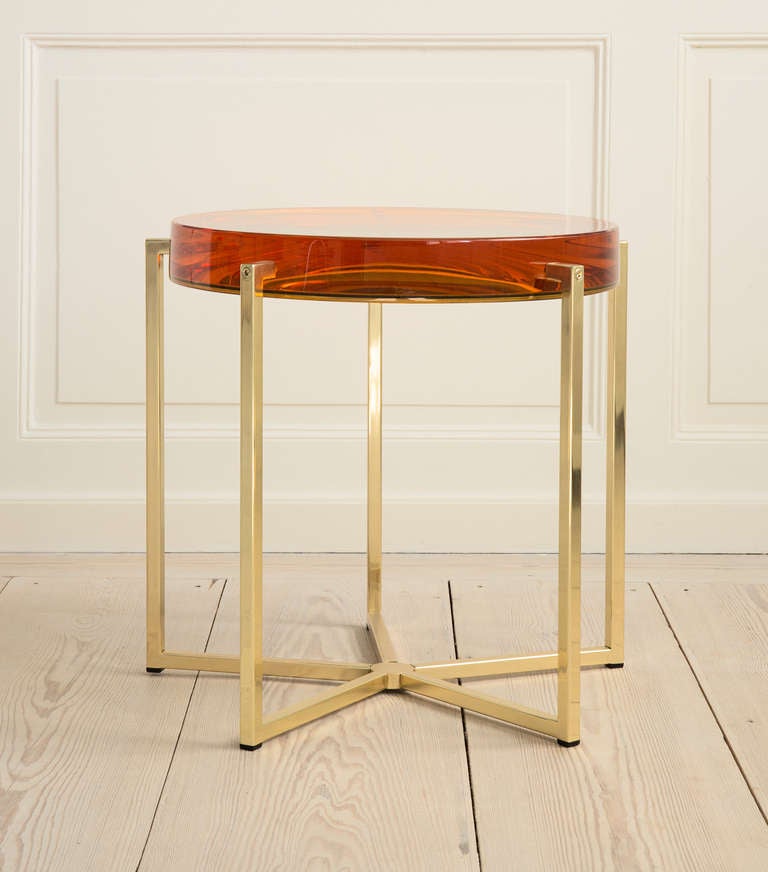 Lens table with amber tinted resin top backed by acrylic mirror on brass base.