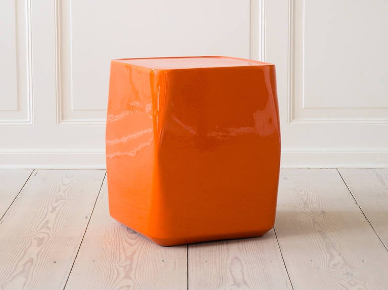 Beautiful ceramic side table in a deep orange glazing. Elegant rectangular shape with rounded corners.