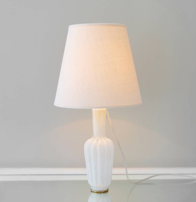 Elegant Murano table lamp in white tinted glass with gold flecks. Brass fittings. Available individually or as a pair.