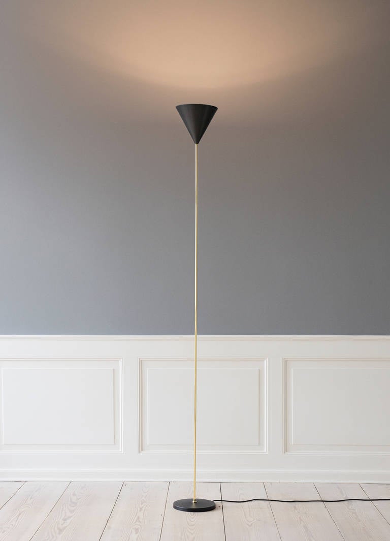 Elegant floor lamp designed by Luigi Caccia Dominioni in 1953. Stem in polished brass, base in black painted cast iron. Reflector in metallic grey aluminium. Contemporary re-edition by Azucena.