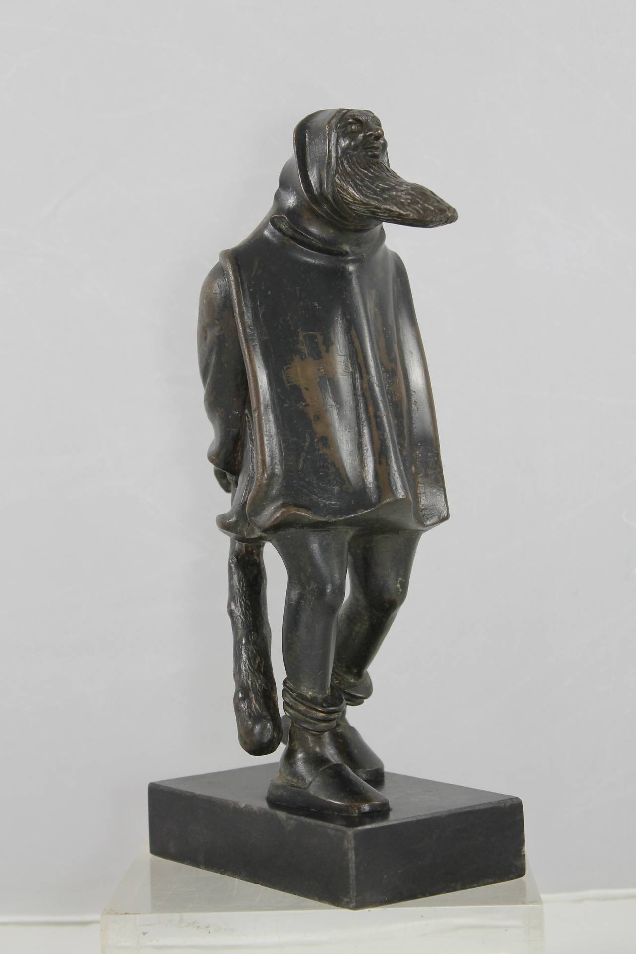 A Rare, patinated bronze wild Man with a long beard and a bludgeon in his hands. On his gown (with hood) is an engraved cross.
The base of ashlar is recently.
