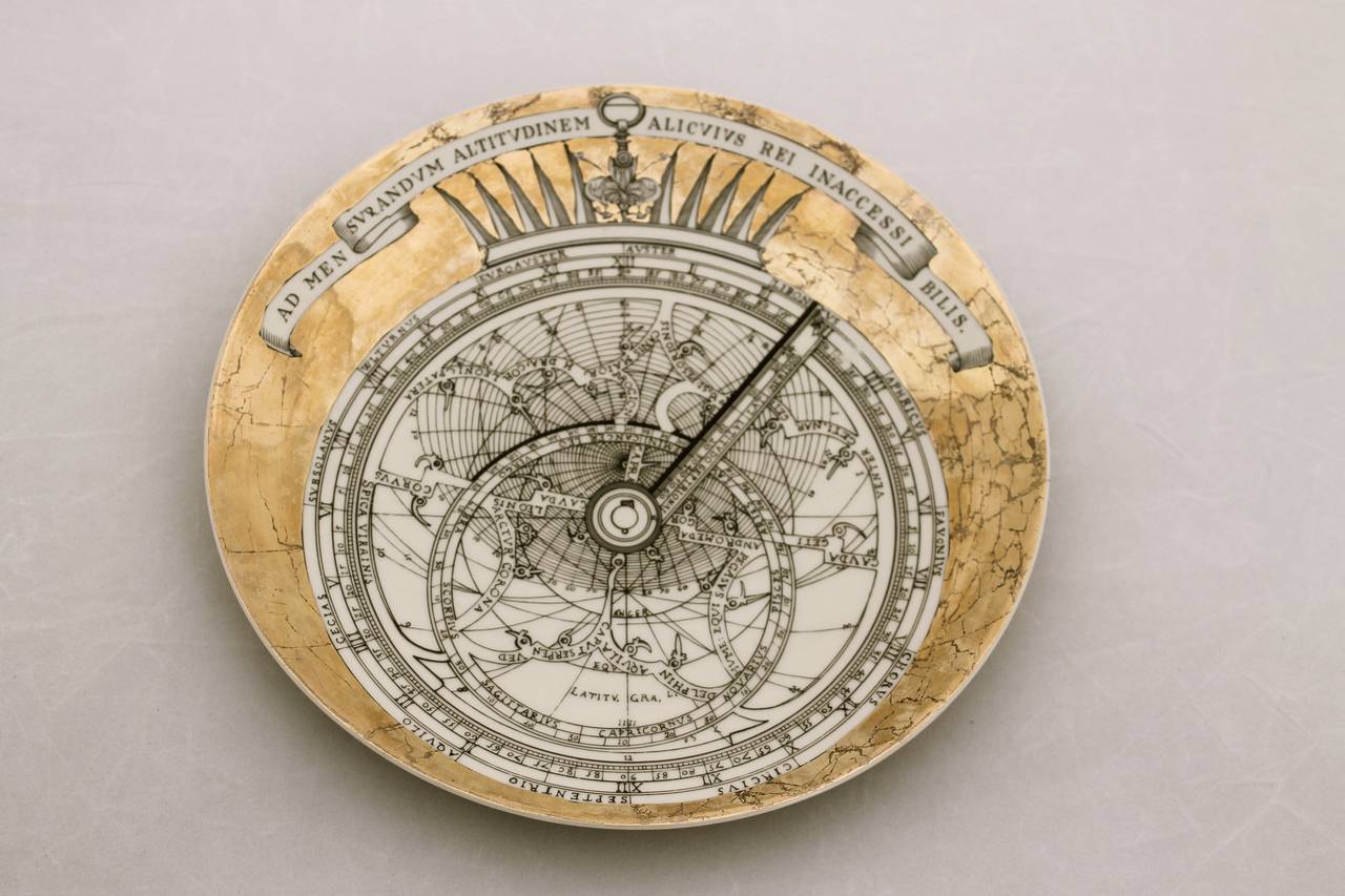 The gilded plates have a central panel in black and white depicting a globe with circular bands containing different images of astrology with banners above reading different latin proverbs. They where Christmas presents from
a Dutch firm (Van