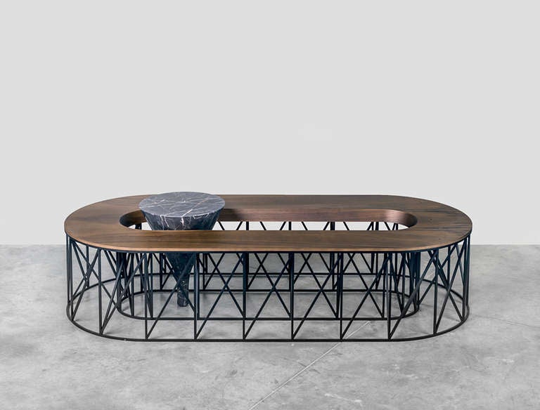 The coffee table like a pressure.

It’s a game of disproportion between different scales, a light and long structure maintaining a heavy barrel of marble. Inspired by structures of amusement parks or ghost trains, the base consists of a repetition