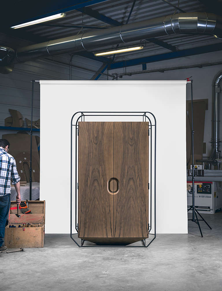 The wardrobe as a suspension.

 A heavy and Minimalist monolith that seems to float, like it is in levitation. An exoskeleton that surrounds it and contrasts with it, empty and complex at the same time. The wardrobe, block of pure wood is set like