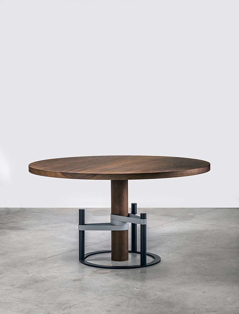 The table like a tension. 

Inspired from props that support young trees, it’s an embrace between the table and its support, made of metallic straps without which it would fall down. The table top and its barrel are massive and plain, as if