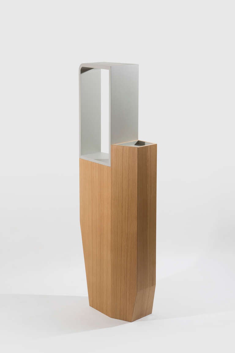 The Chou-Chou totem is marked by verticality. It is made of the assembly of rough wood and lacquered wood. The massive base is thought like a thrusting carved monolith on top of which a rounded niche is laid that will nicely highlight stored