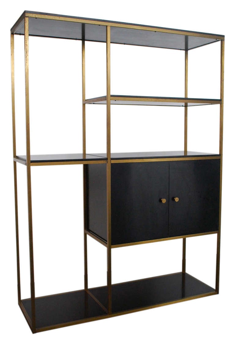 Designed by Robert Feller and Mark J. Furst in 1957 in the style of Paul McCobb, this lovely free-standing Furnette Shelving Unit is in its original vintage condition. The high-gloss back lacquered shelves and drawers complimented by a brass frame