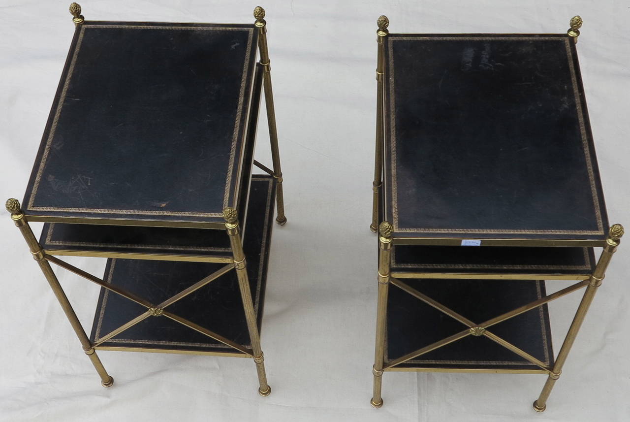 Pair of shelves with three levels with black leather and gold grecs motifs, amount bronze and brass, and pine cones, circa 1970. Good condition.