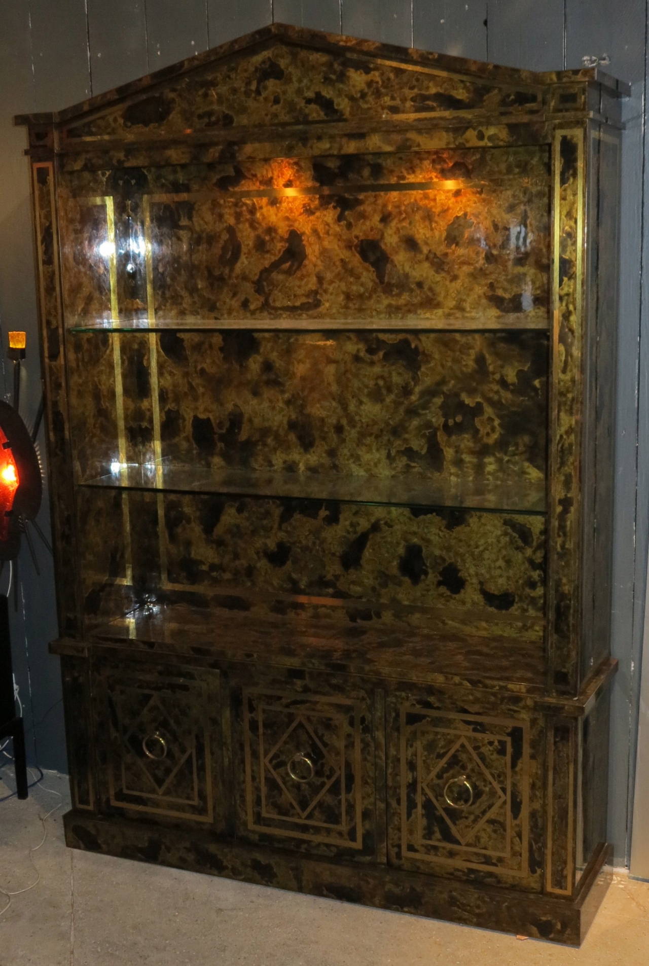 Bookcase Directoire sheathed by oxidized and inlaid brass of nets of golden and polite brass, 1950-1970 part of the top lit by lamps, etageres three doors in the bottom closed by magnets, good condition.