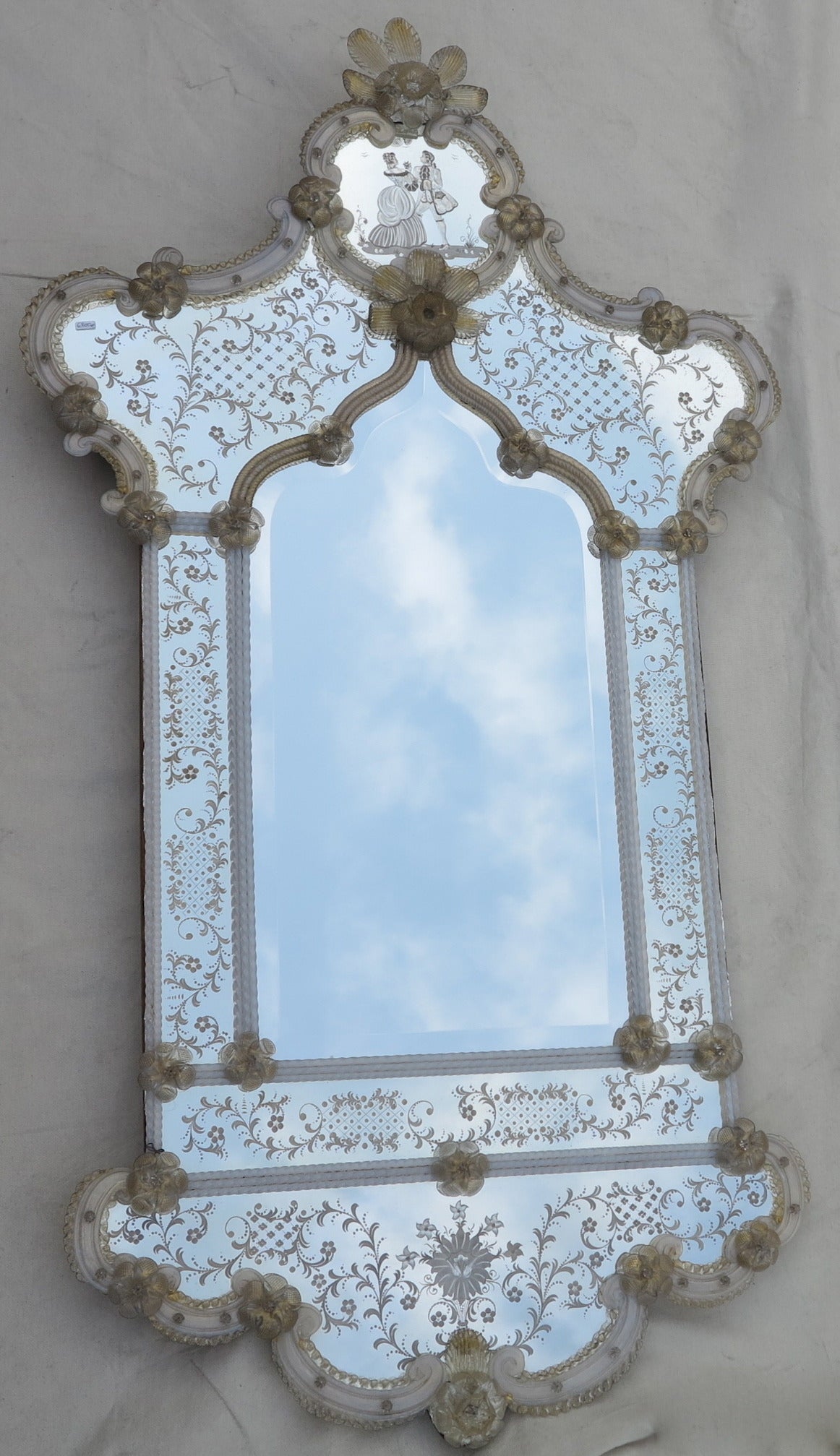 Mirror Murano has parecloses engraved by flowers and characters on the front wall, woman has flowers and gentleman and birds in the sky, ornament of flowers, leaves gilded with gold and méandres and twist opalescent. Good conditions, circa 1950,