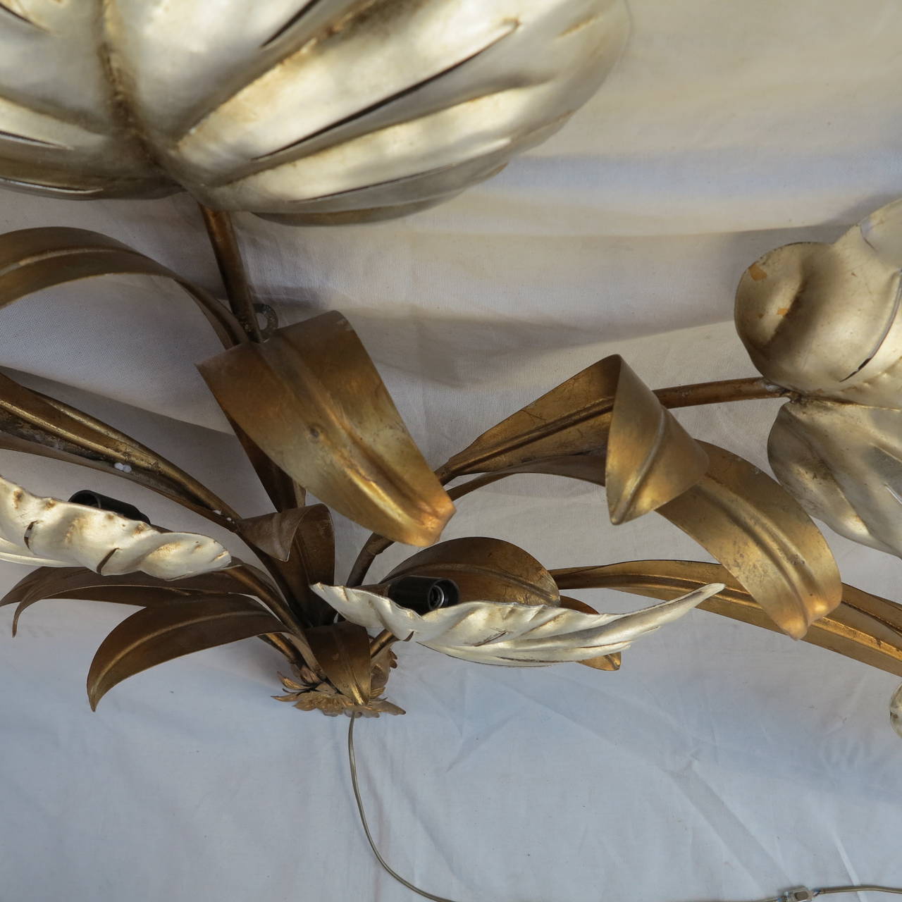 Gold-colored and silvery iron wall lamps, seven lamps lighting silvered leaves, good condition, circa on 1970.