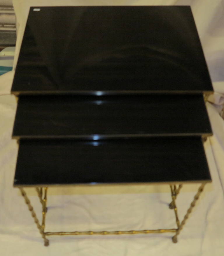 Series three tables bronze bamboo decor, the trays are black lacquered wood, amounts ending shaped feet. Circa 1950-1970.<br />
Sizes: 55X40X H 50 cm, 51X38X H48cm 57 X36 X H46, belts bronze screwed.