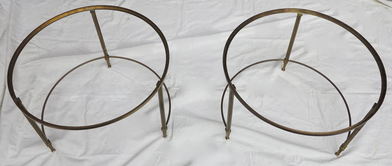 Pair of round tables with basic arc open, gilded bronze, glass top and adjustable screw feet, circa 1950-1970.