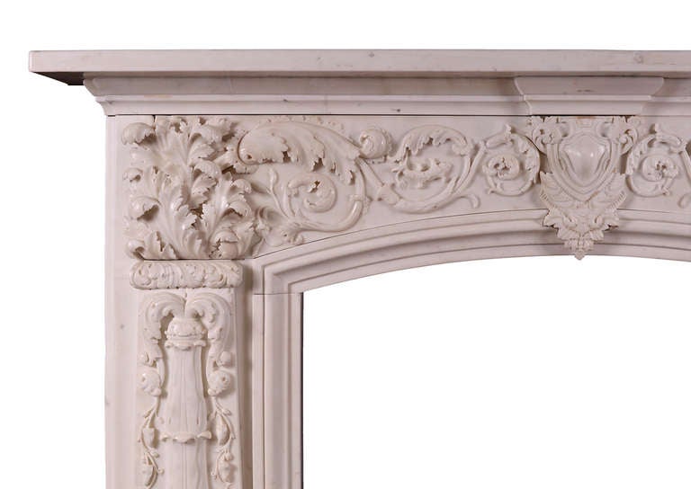 An exceptionally carved late Regency Statuary marble fireplace. The arched frieze with carved cartouche to centre flanked by scrolled foliage and particularly beautiful carved leafwork. The jambs with carved, tapering columns with cascading foliage.