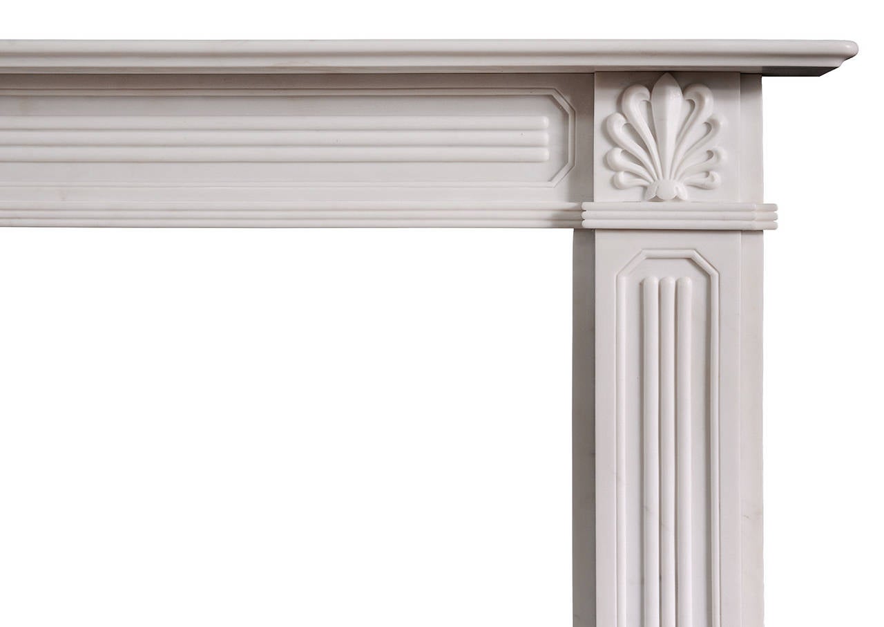 A charming Regency style white marble fireplace, with delicately carved athemion side blocks. Octagonal panels to frieze and jambs with reeded centres. Reeded moulding to underside of frieze, and moulded shelf. A copy of a period English Regency