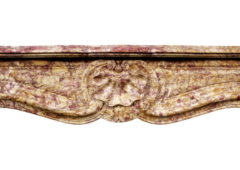 A 19th century French Louis XV style fireplace in Spanish Brocatelle marble. The frieze with shell to centre and carved panels. The panelled jambs surmounted by carved shell and scrolls. Moulded serpentine shelf.

Measures:
Shelf Width:	1195 mm     