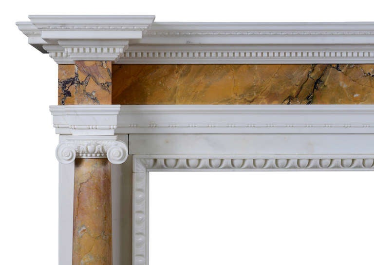 Cheminée de taille moyenne en marbre de Sienne et statuaire de style anglais George II avec colonnes. La sculpture est de qualité, avec des moulures en forme de feuilles et des denticules sur le plateau, ainsi qu'une moulure intérieure en forme