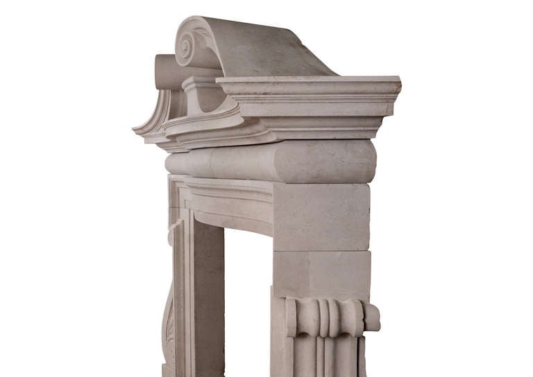 A dramatic English Portland Stone fireplace echoing the Palladian style revived by William Kent and William Jones in the early part of the 18th century. The bow-fronted frieze surmounted by a magnificent broken pediment. Late 19th century, possibly
