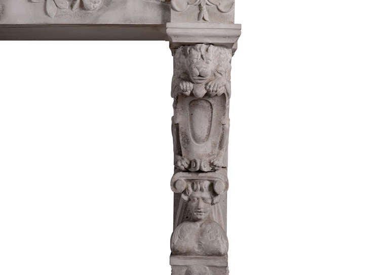 Très rare cheminée Renaissance en pierre sculptée du XIXe siècle. Les jambages à consoles sont ornés de lions accroupis, de chapiteaux ioniques, de masques masculins et féminins sculptés et d'une corbeille de fruits sur des socles. La frise est