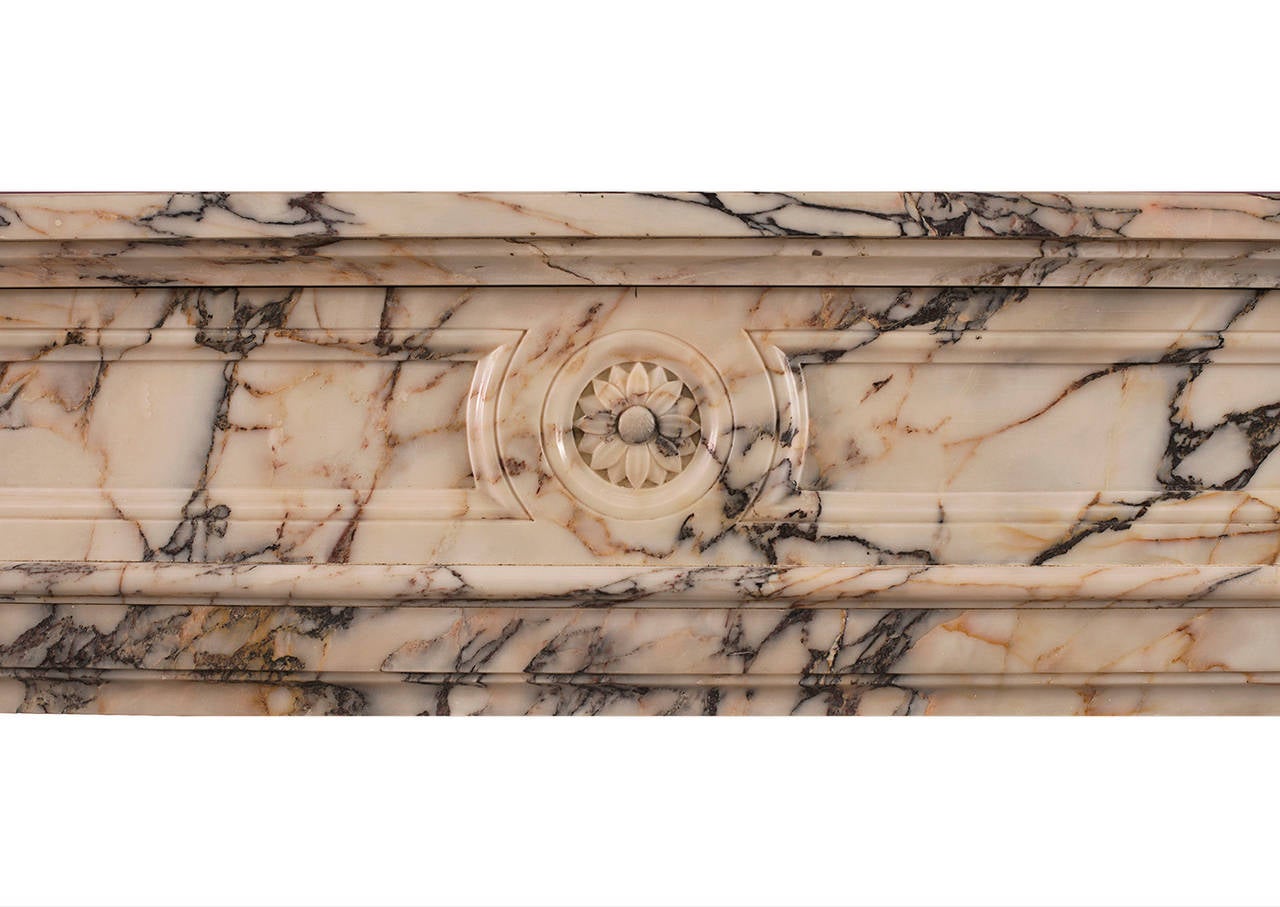 A 19th century French Louis XVI style demilune fireplace in Breche Violette marble. The shaped, fluted legs with carved paterae above, the panelled frieze with carved rosette to center. Shaped moulded shelf.

Measurements:
Shelf width - 1465 mm 57