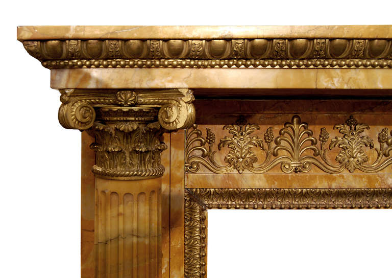 Ein sehr bedeutender französischer Empire-Kamin aus Siena-Marmor des 19. Jahrhunderts (um 1820) mit kunstvollen Goldbronze-Verzierungen an Fries und Pfosten. Die kannelierten Säulen werden von korinthischen Kapitellen aus Goldbronze gekrönt, die ein