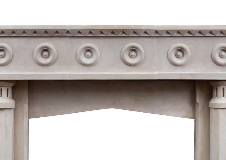 An unusual English limestone fireplace with a Gothic influence. The four hexagonal front columns supporting solid frieze with roundel decoration. The shelf with triangular detailing to front and sizes. 19th century with later amendments.

Shelf